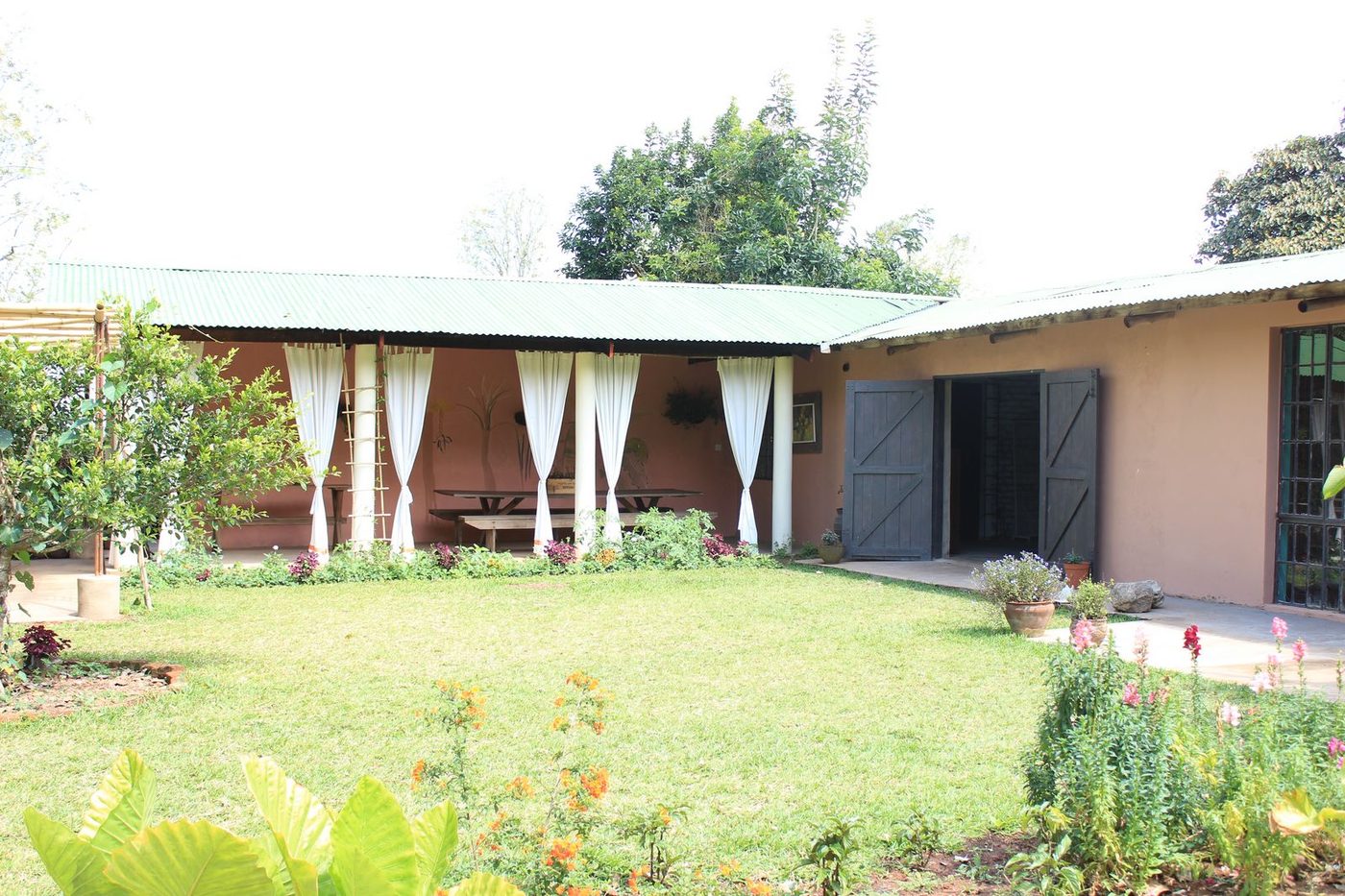 Restaurant building with white curtains, garden, and flowers