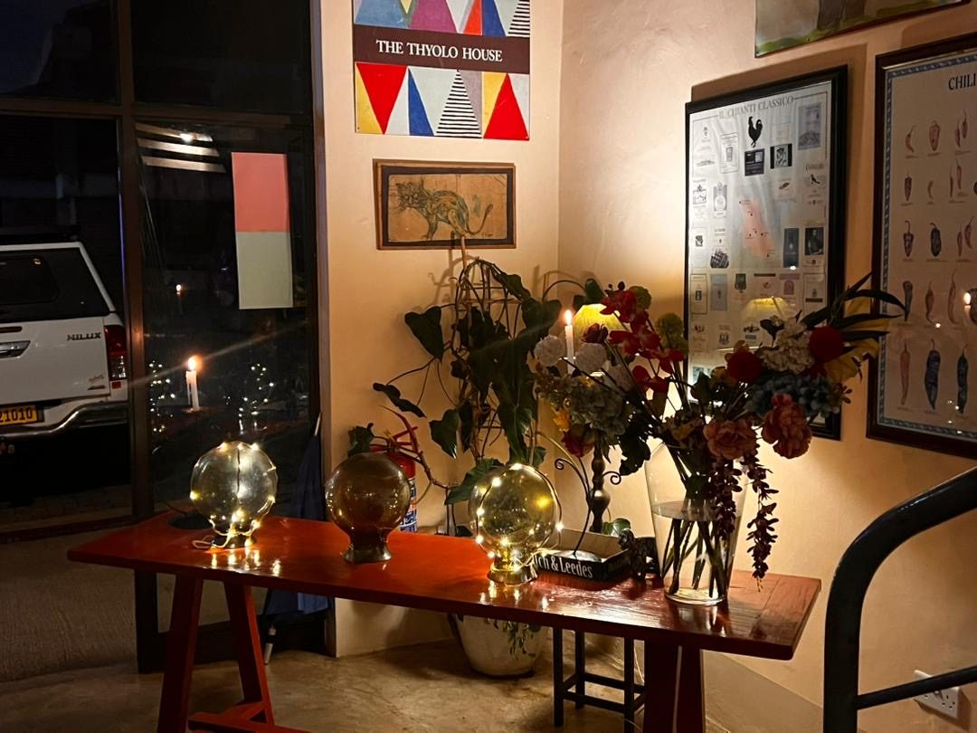 Restaurant entrance at night with candles and The Thyolo House sign